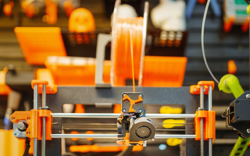 3D printer extruding material for a precision part